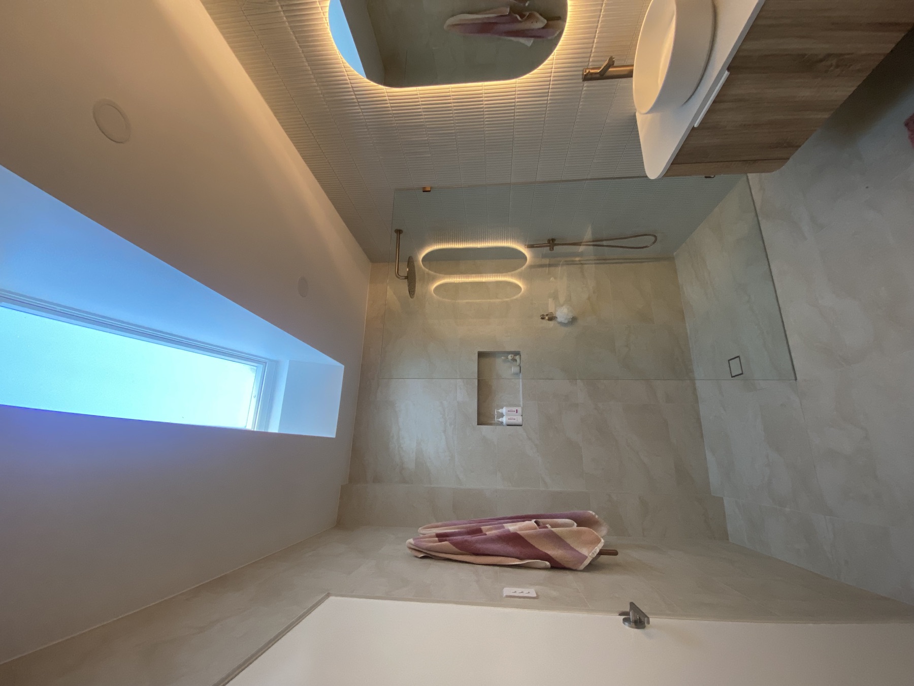Completed LS Building Solutions bathroom renovation with skylight, glass shower and custom vanity